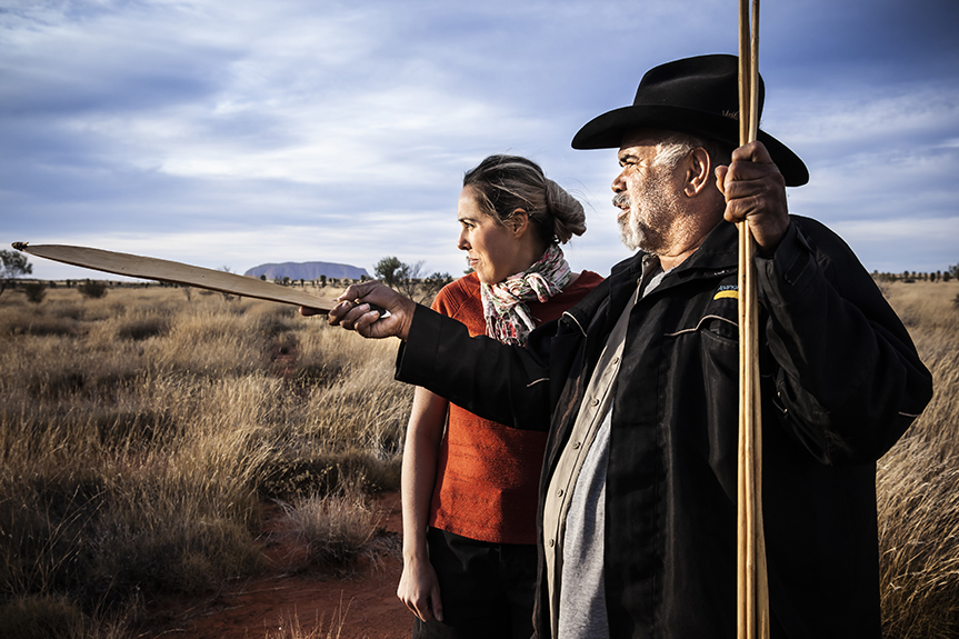 An anangu man points something out to a guest