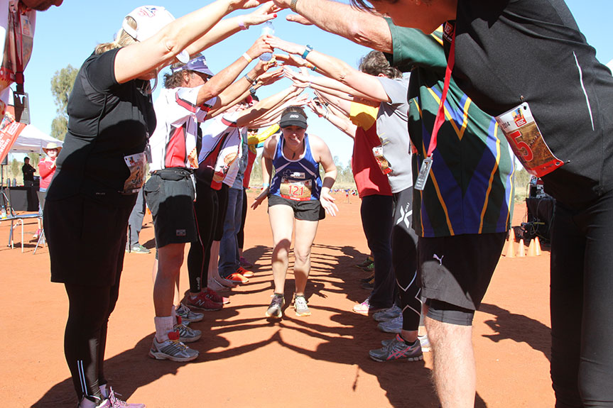 A woman runs through a human tunnel of supporters 