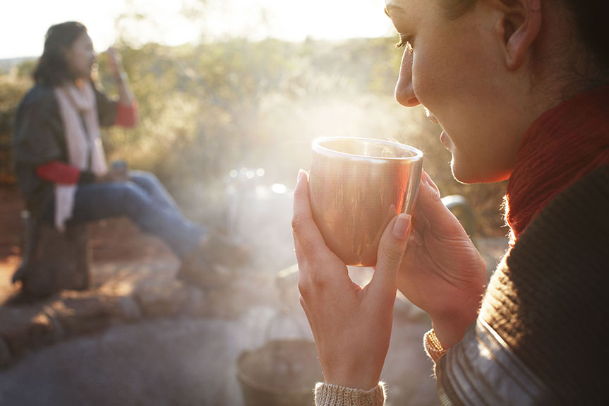 A woman drinks from a cup at Desert Awakenings