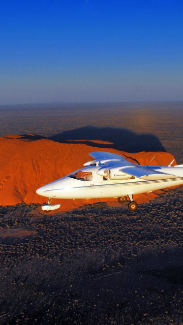 plane in the air over Ayers Rock